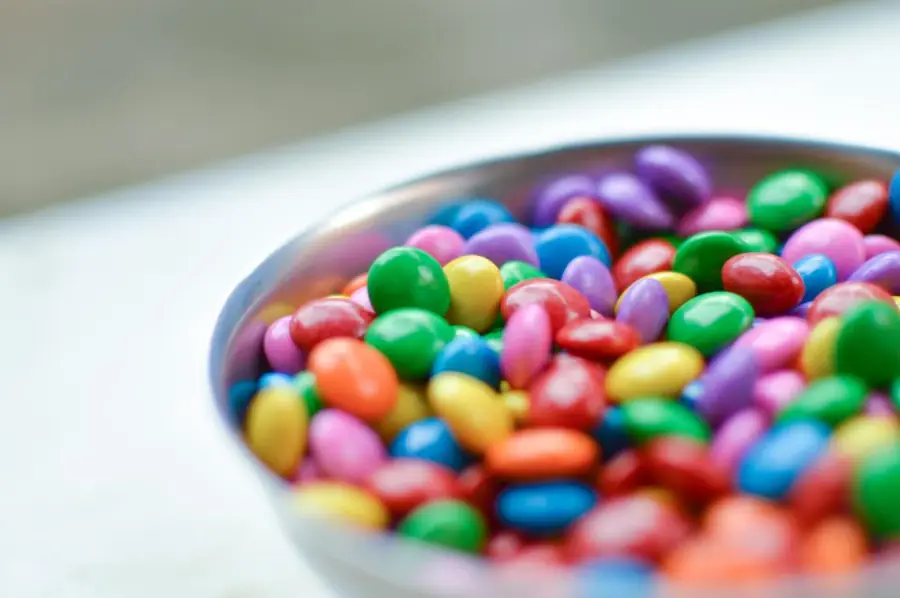 Tazón metálico con grageas de chocolate de colores